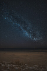 Night skyscape of a starry sky at the seashore. Stars constellations and Milky Way galaxies in the night sky. Concept of dreaming and stargazing.