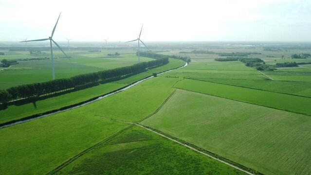 view of landscape with greenfields and windmills in the Netherlands