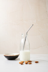 Half a bottle of almond milk straw nuts vegan milk copy space