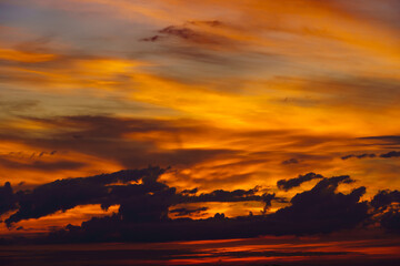 beautiful dramatic sunset sky, bright sunlight and dark silhouette of clouds as a background