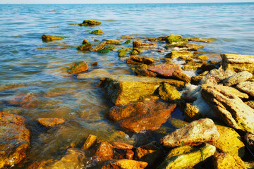 beautiful summer seascape, seashore on a bright day, stones and splashes of waves