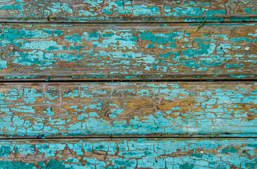 old boards as an abstract wooden background, painted with green paint that peels off