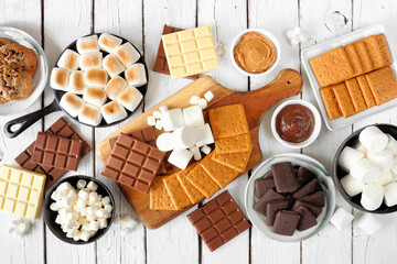 Smores buffet table scene. Roasted marshmallows, crackers, chocolate and a selection of...