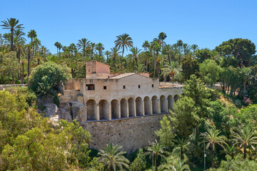 Fototapeta premium Molí del real with palm trees in the municipal park in Elche. Old 18th century mill. Located in Valencian community, Alicante,Elche, Spain.
