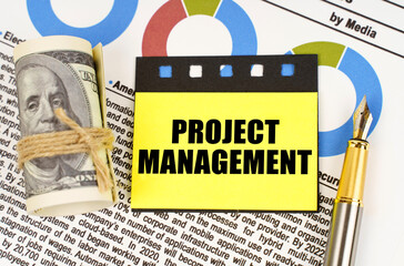 On documents with diagrams there are dollars, a pen and yellow stickers with the inscription -...
