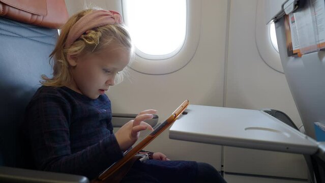 Kid using tablet computer to draw in the airplane