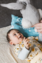 little white-skinned boy with black hair lying on the bed (selective focus)
