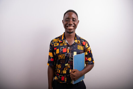 Young smiling college student in the photo studio holding his portfolio