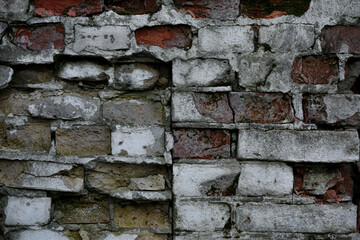 Old Red brick wall with crumbled bricks. The texture of an old dark brown and red brick wall. Stone wall texture. Old brick wall. 