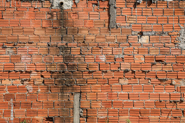 Wall mute with exposed brick, unfinished and with time marks, highlighting its texture.
