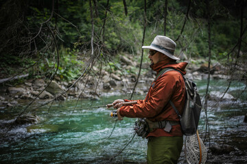 Fishing background. Fisherman catching trout on a river.	