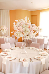 festive wedding decoration. Beautiful fresh white and pink flowers in glass vase on dining table on wedding day. High quality photo