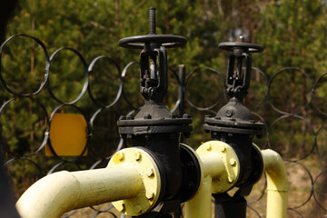Fototapeta premium Yellow gas pipes and valves outdoors. gas equipment. Copy space for text. High quality photo