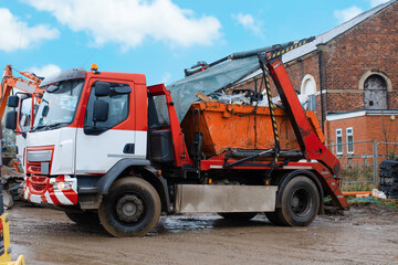 A truck self-loading industrial skip. Taking skip full of rubbish from a construction site for...