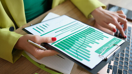 Female accountant using laptop for typing financial report