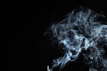 incense stick with smoke against black background