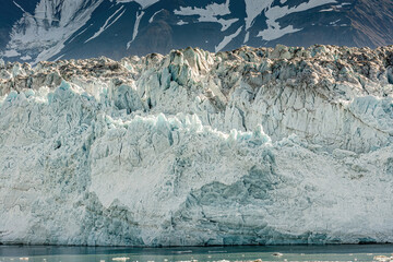 Disenchantment Bay, Alaska, USA - July 21, 2011:Blue and black spotted Ice wall of Hubbard Glacier...