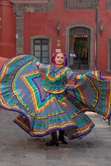 Young Mexican woman in a traditional folklore dress of many colors, traditional dancer.