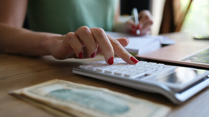 Fototapeta premium Woman doing calculation of expenses and income and making notes