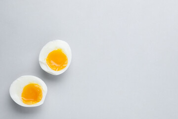 Halves of fresh soft boiled egg on white background, flat lay. Space for text