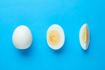 Fresh hard boiled eggs on light blue background, flat lay