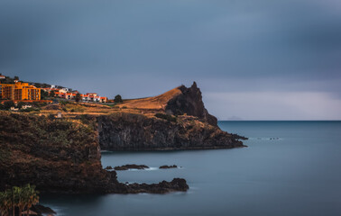 Fototapeta na wymiar Coastline of Canico de Baixo and Reduto do Portinho rocks at sunrise. Madeira, october 2021. Long exposure picture