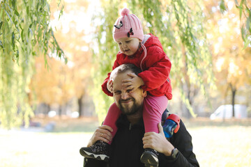 Happy father and child spending time outdoors. father with daughter in autumn park