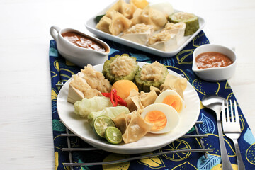 Baso Tahu or Siomay Bandung, Popular Traditional Indonesian Street Food from Bandung, West Java. Made from Fish Cake, Potato, Boiled Egg, Served with Spicy Peanut Sauce, Sweet Soy Sauce, and Lime.