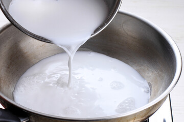 Fototapeta na wymiar Chef Pouring Coconut Milk to the Pan