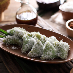 Lupis, Indonesian Traditional Snack Made From Sticky Rice, Wrapped with Banana Leaf, Shape Triangle  Served with Liquid Palm Sugar and Grated  Coconut