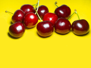 Yellow background and ripe cherries. Berries on yellow. Juicy fruit. Ingredient for compote. Nature