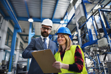 Engineering manager and mechanic worker doing routine check up in industrial factory