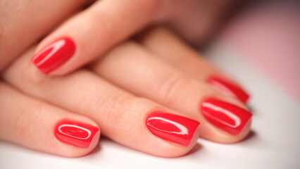Woman hands with perfect bright red glossy manicure