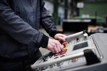Close-up of engineer working at machine in industrial factory