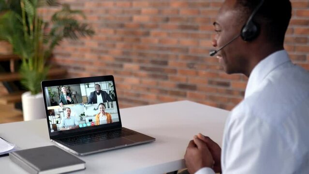 Online business meeting of multiracial group. Successful african american man looking at computer screen, talking on video link, talking strategy and workplan, discussing project,plans company future 