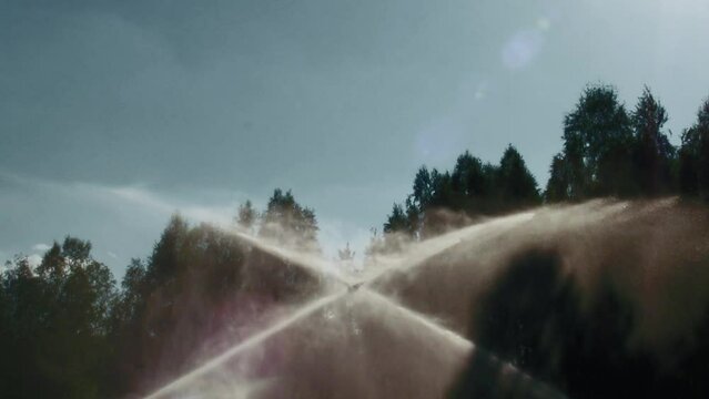 watering the lawn in slow motion on the golf course from two sides