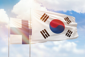 Sunny blue sky and flags of south korea and finland