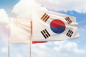 Sunny blue sky and flags of south korea and malta