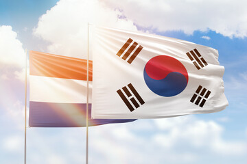 Sunny blue sky and flags of south korea and netherlands