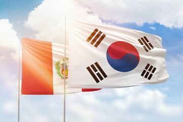 Sunny blue sky and flags of south korea and peru