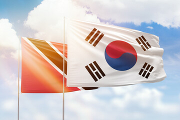 Sunny blue sky and flags of south korea and trinidad and tobago