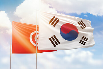 Sunny blue sky and flags of south korea and tunisia