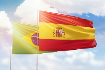 Sunny blue sky and flags of spain and brazil