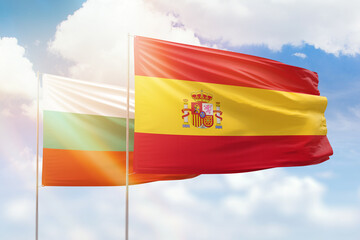 Sunny blue sky and flags of spain and bulgaria