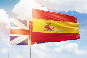 Sunny blue sky and flags of spain and great britain