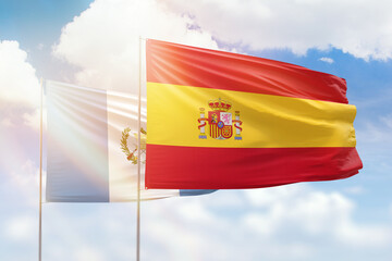 Sunny blue sky and flags of spain and guatemala