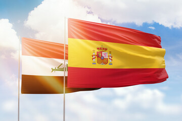 Sunny blue sky and flags of spain and iraq