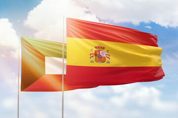 Sunny blue sky and flags of spain and kuwait
