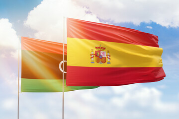 Sunny blue sky and flags of spain and libya