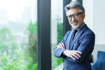 窓辺に立つミドルビジネスマンのポートレート